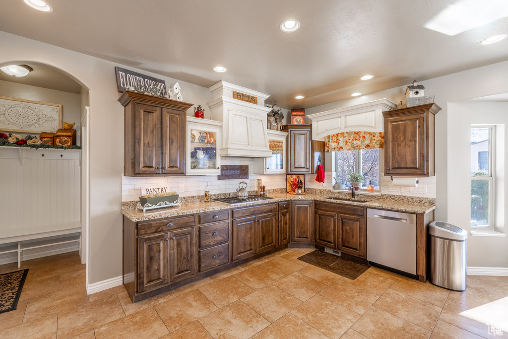 Kitchen featuring stainless steel appliances, plenty of natural light, backsplash, light stone counters, and recessed lighting