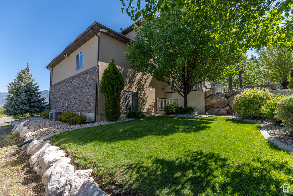 View of home's exterior featuring a yard and stucco siding