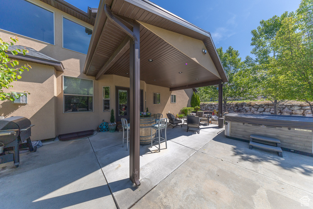 View of patio with a hot tub, an outdoor hangout area, and area for grilling