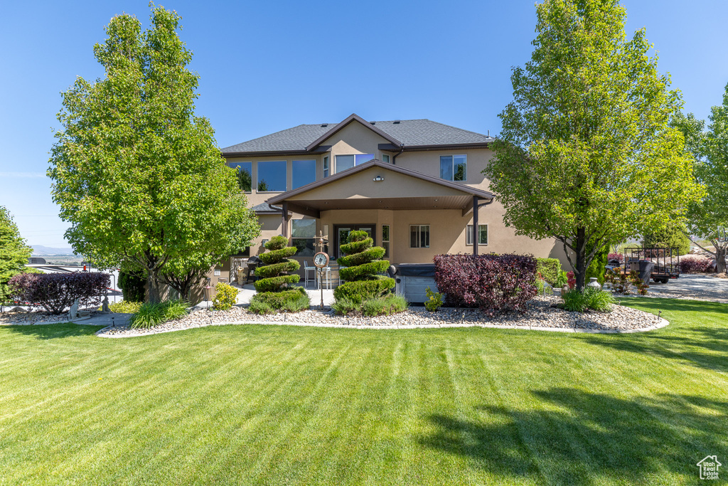 View of front of property with a front lawn and stucco siding
