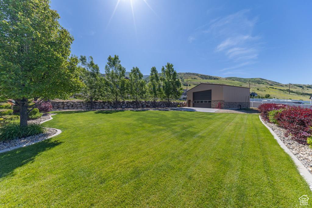 View of yard featuring a mountain view, a garage, and an outdoor structure