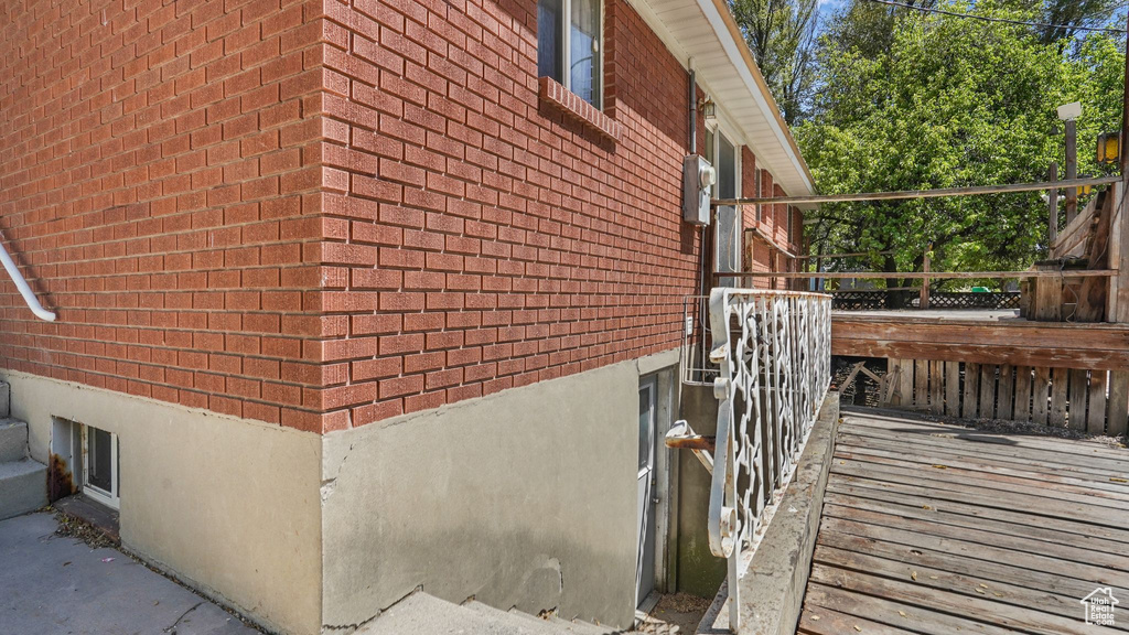 View of side of property with brick siding and a wooden deck