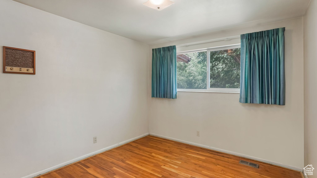 Empty room featuring baseboards and wood finished floors