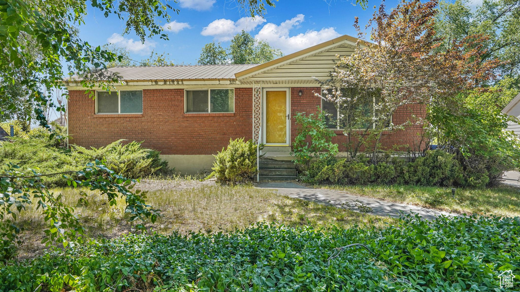 Single story home with brick siding and a metal roof
