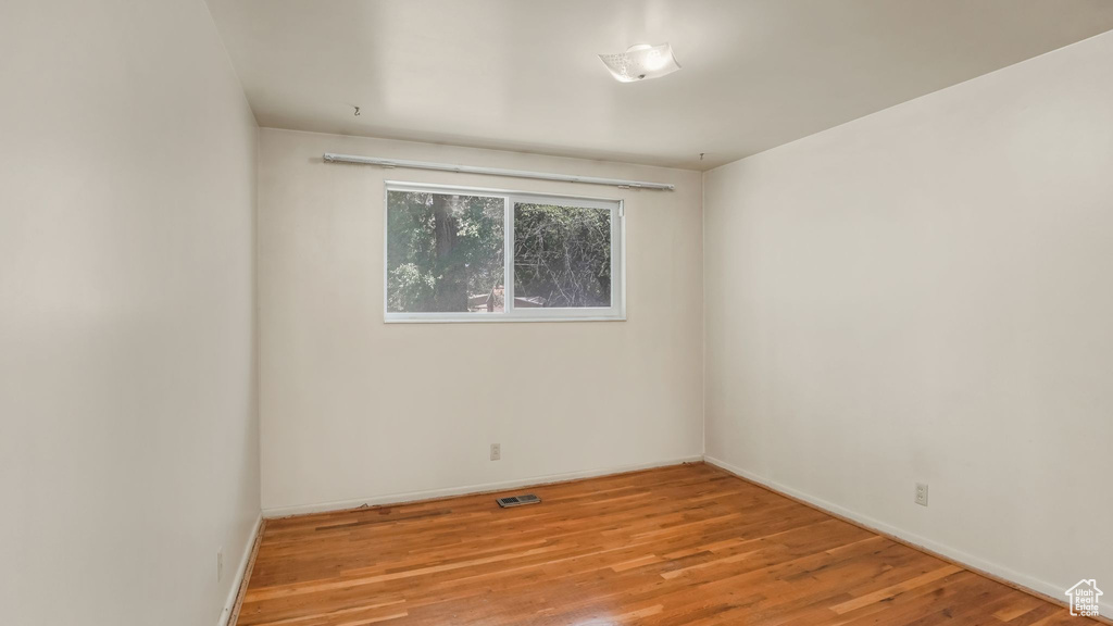 Empty room with baseboards and wood finished floors