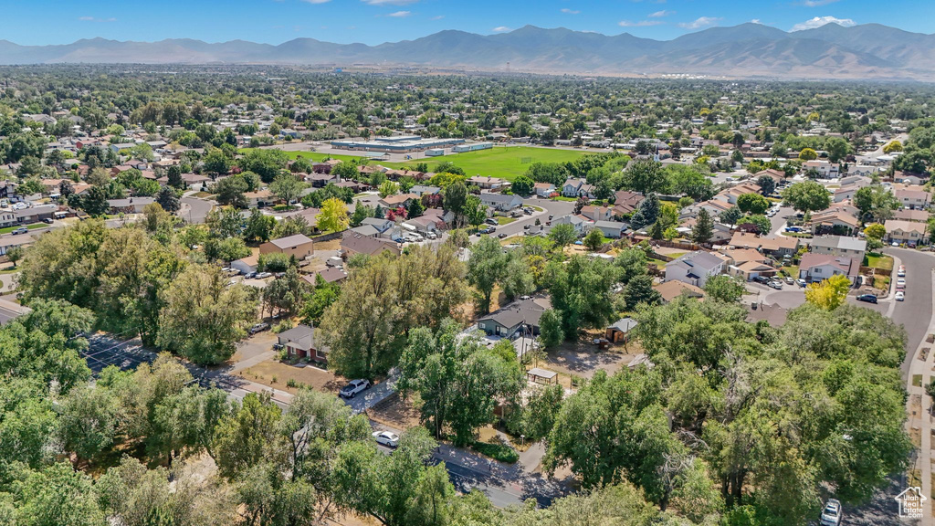Aerial view of property and surrounding area with a mountain backdrop and nearby suburban area