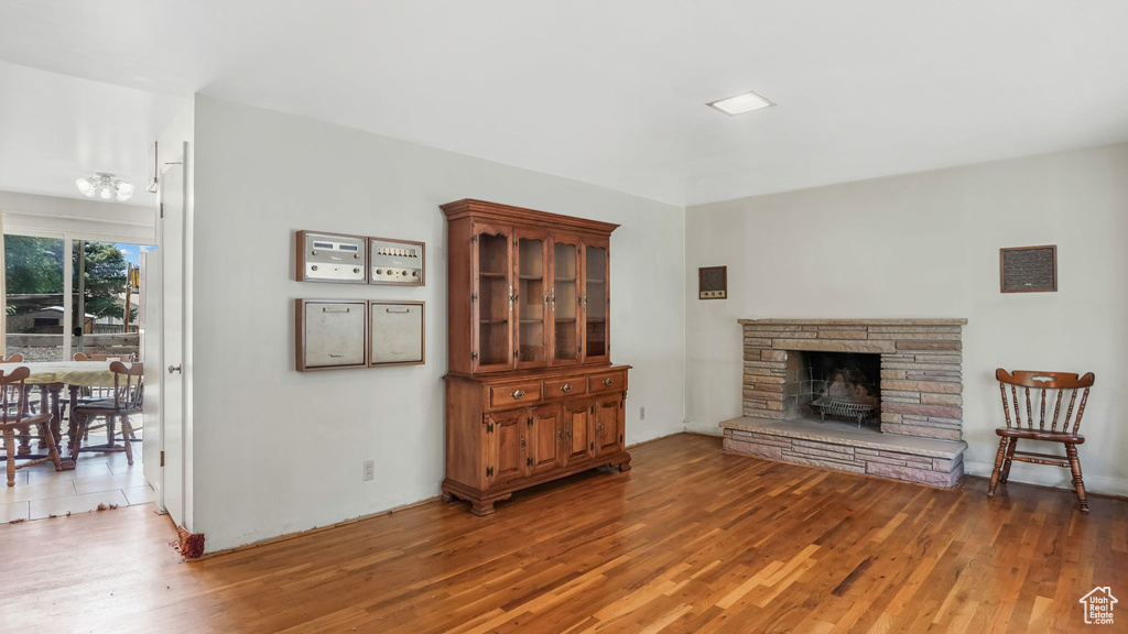 Living room featuring light wood-style floors and a stone fireplace