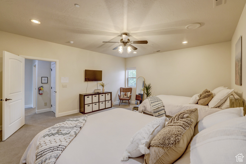 Bedroom with light colored carpet, recessed lighting, and a ceiling fan