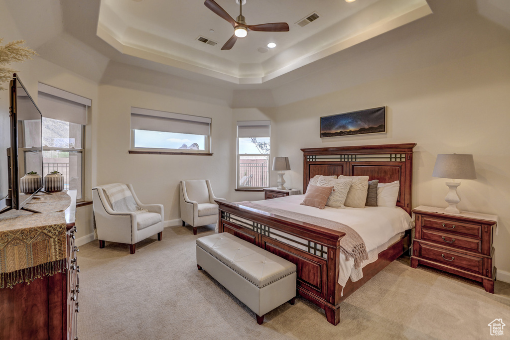 Bedroom with a tray ceiling, light colored carpet, a ceiling fan, and recessed lighting