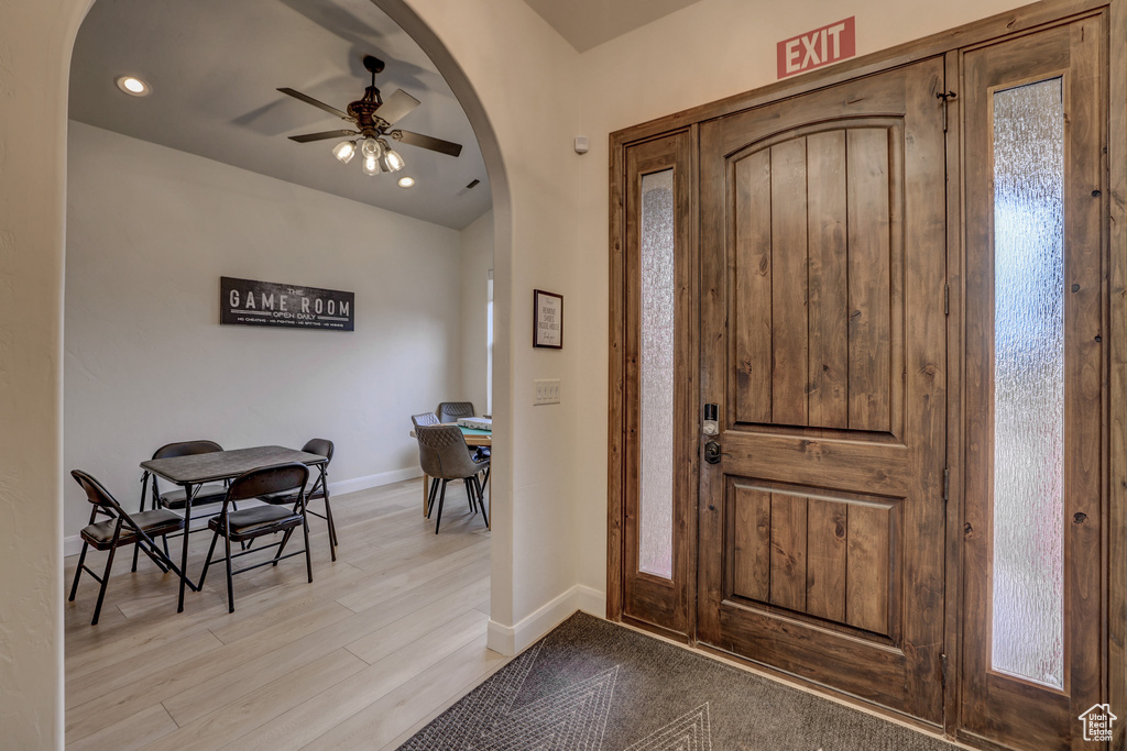 Foyer with arched walkways, ceiling fan, light wood-style floors, and recessed lighting