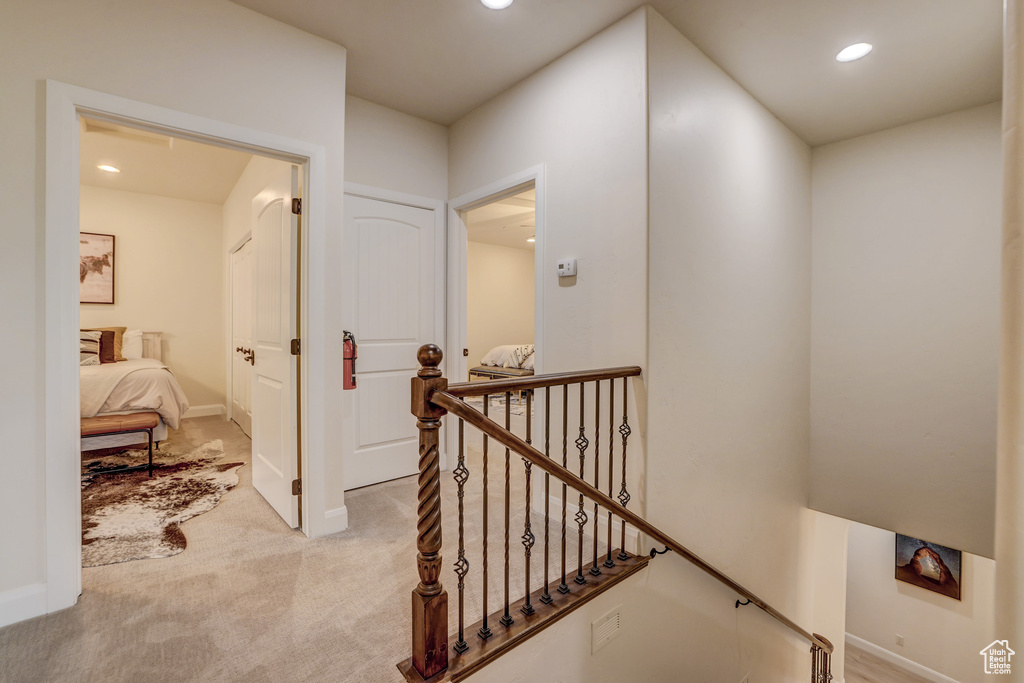 Hall featuring recessed lighting, an upstairs landing, and light colored carpet