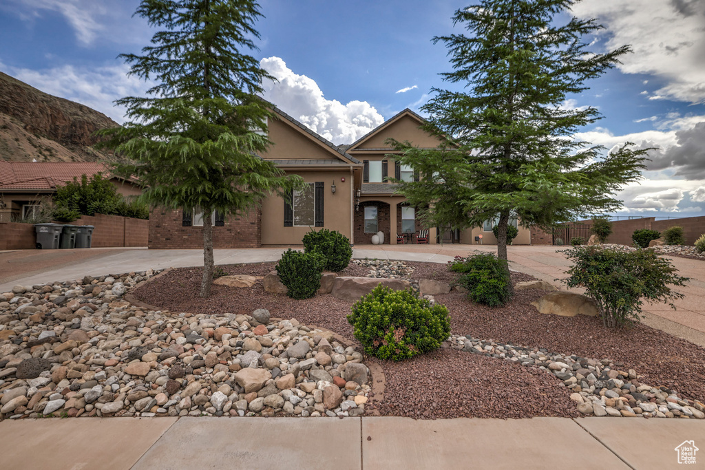 View of front facade featuring curved driveway and stucco siding