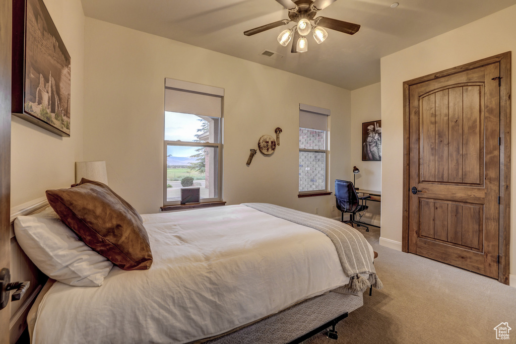Carpeted bedroom featuring ceiling fan and baseboards