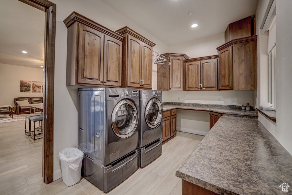 Laundry area featuring cabinet space, washing machine and dryer, light wood finished floors, and recessed lighting