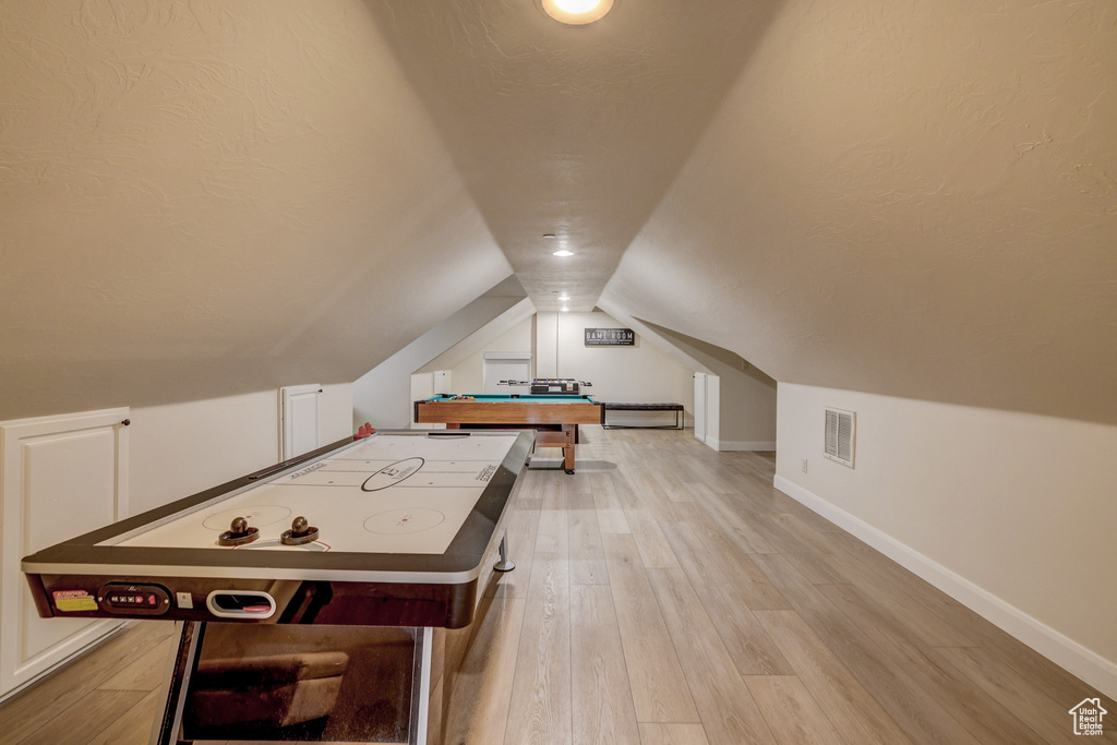 Rec room featuring vaulted ceiling, light wood-style floors, and pool table