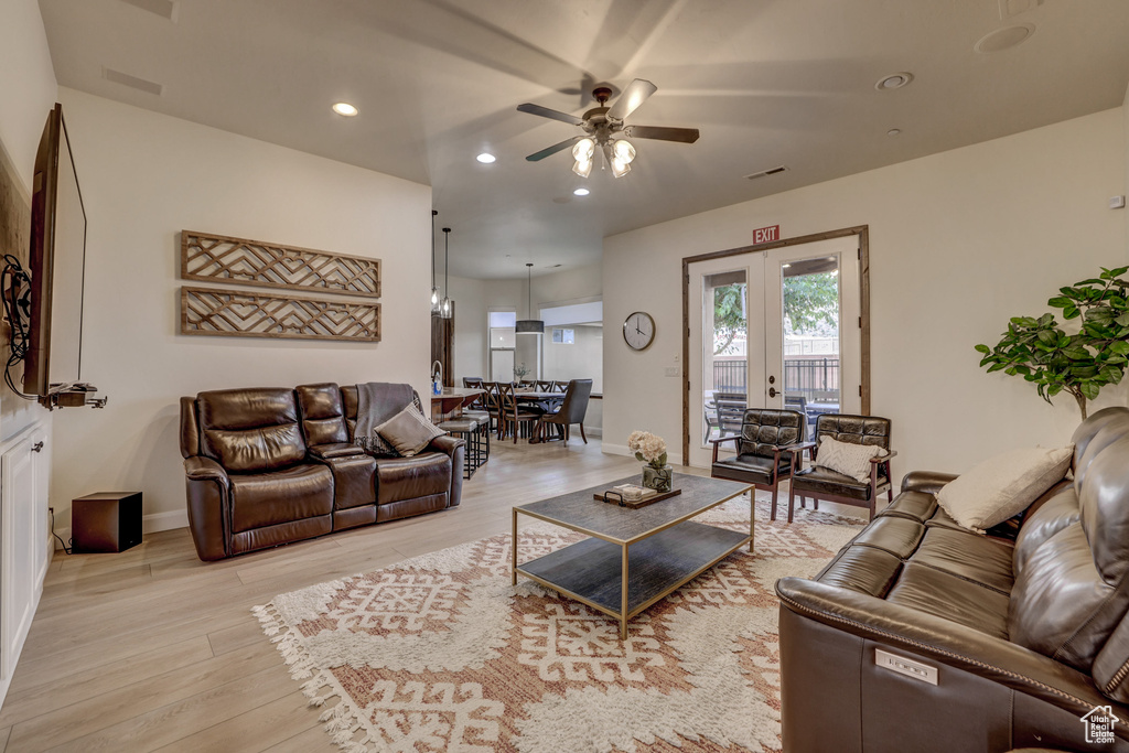 Living room with ceiling fan, light wood-style flooring, recessed lighting, and french doors