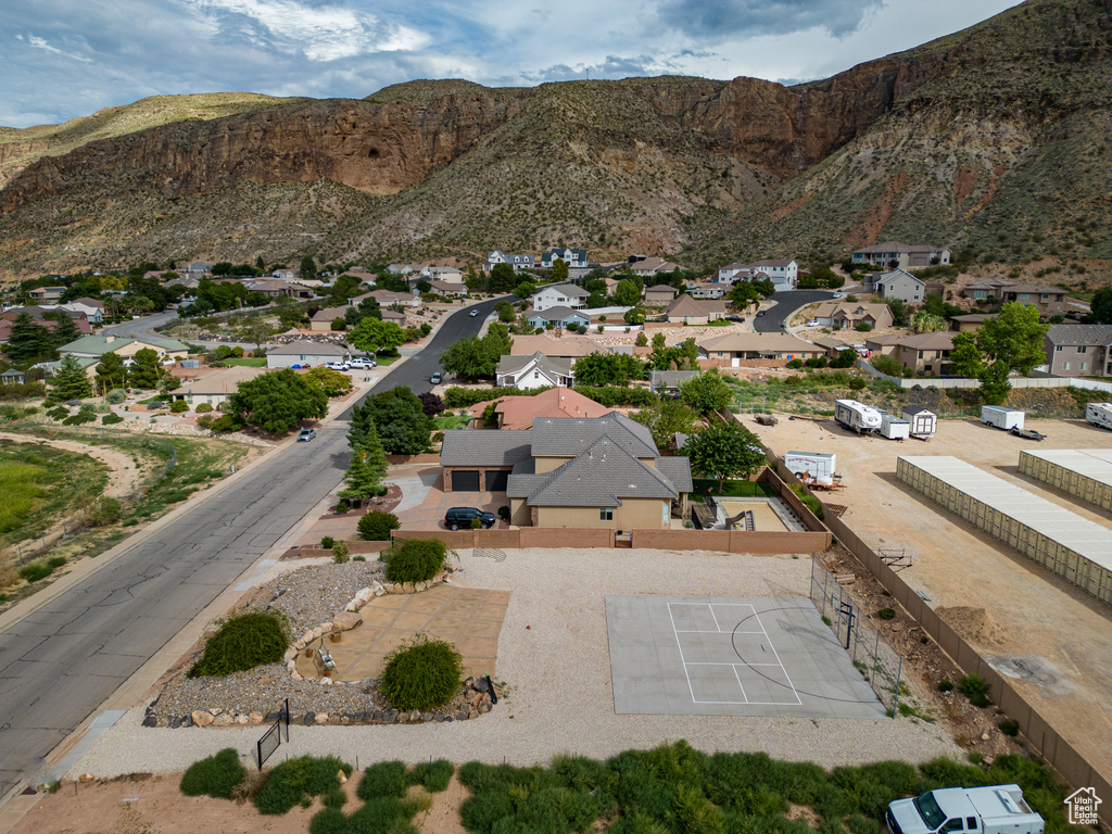 Aerial view of property and surrounding area featuring mountains and nearby suburban area