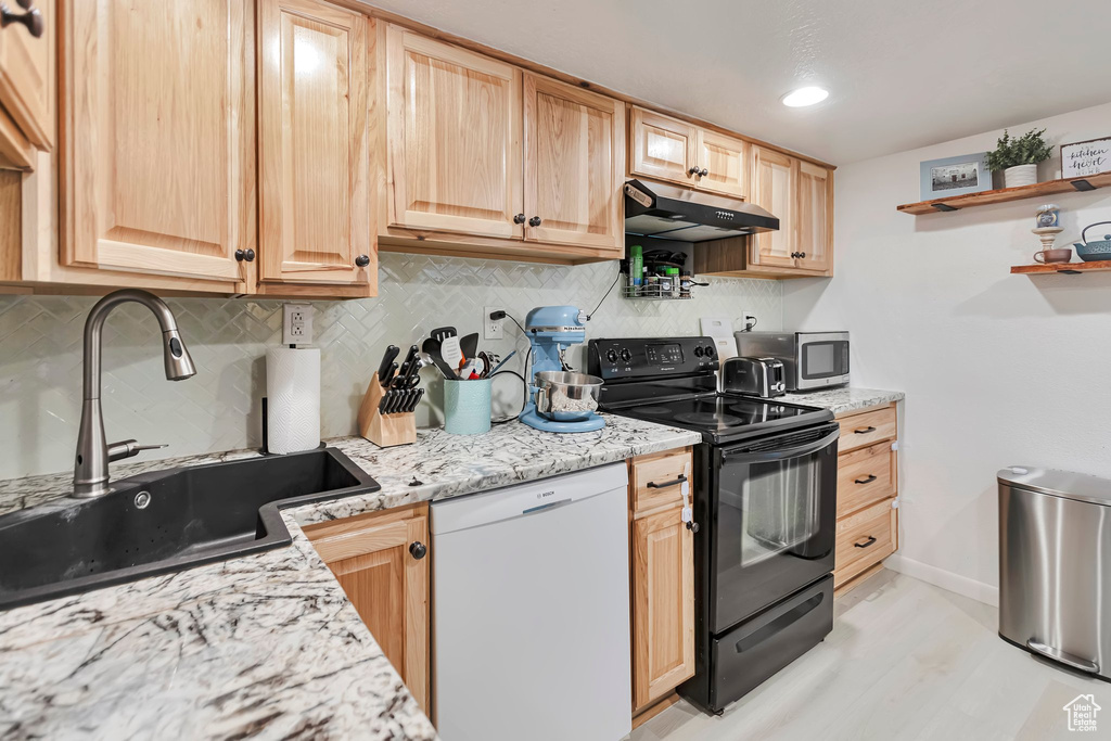Kitchen with black / electric stove, dishwasher, under cabinet range hood, and backsplash
