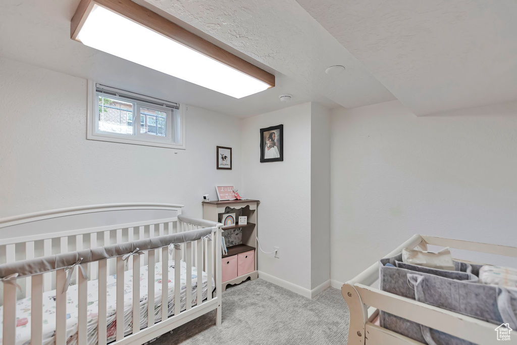 Bedroom with carpet flooring and a crib