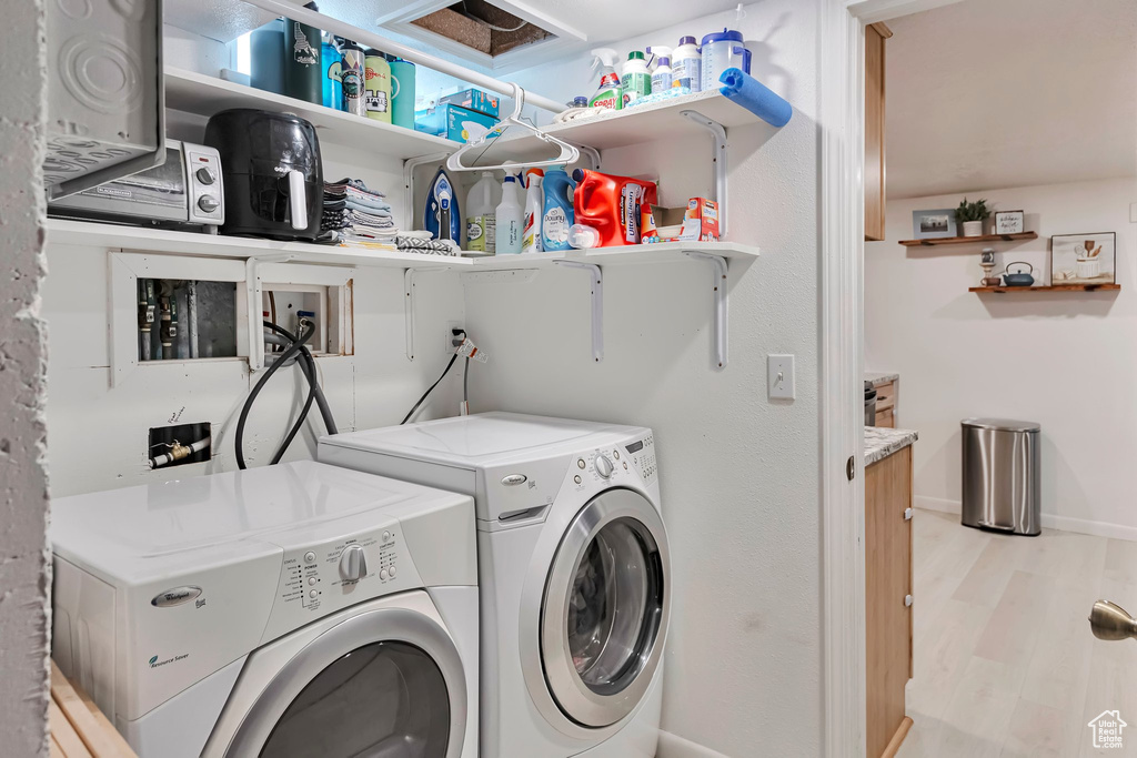 Washroom featuring washer and clothes dryer and light wood-style flooring