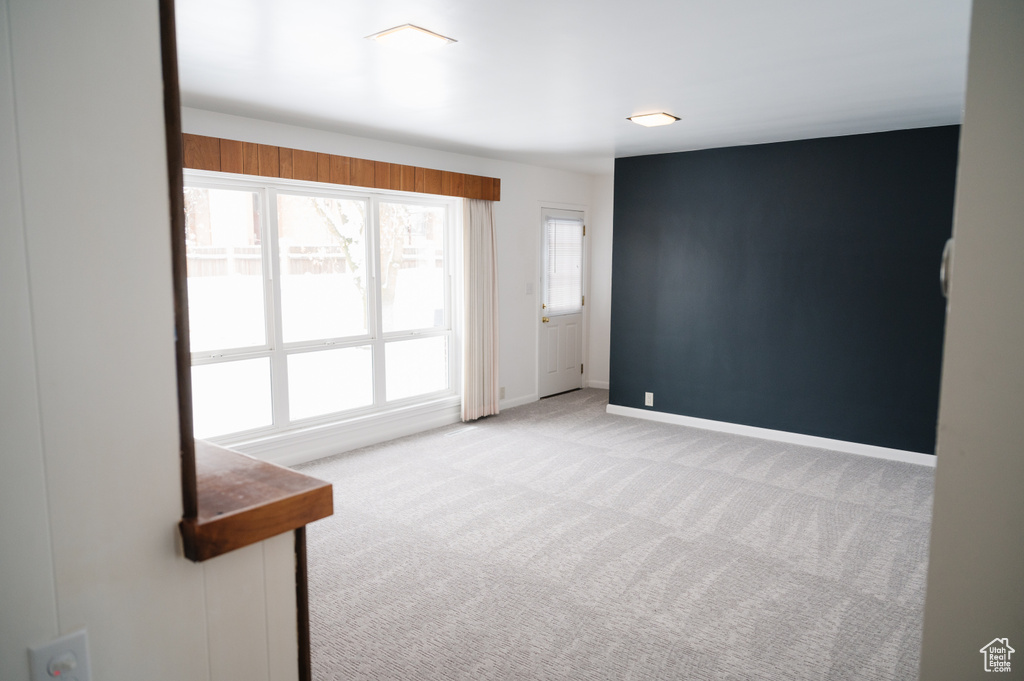 Spare room featuring carpet flooring and baseboards