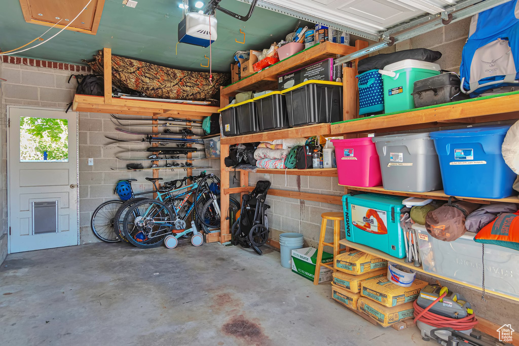 Garage featuring a garage door opener and concrete block wall