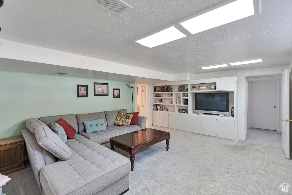 Carpeted living area with a textured ceiling