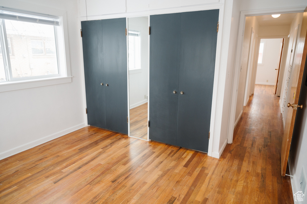 Unfurnished bedroom featuring a closet and light wood-style floors