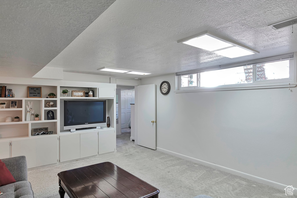 Living room with a textured ceiling and light carpet