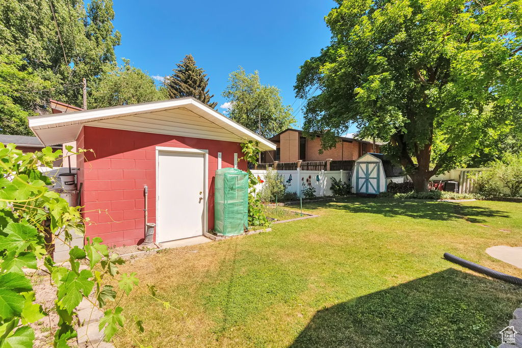 Fenced backyard featuring a storage unit