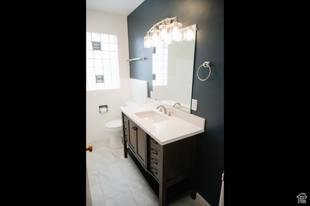Bathroom featuring vanity and marble look tiles