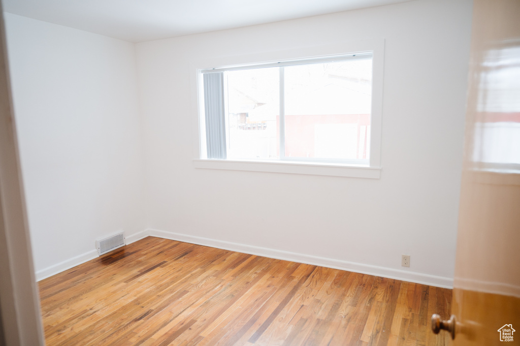 Unfurnished room with light wood-style flooring and baseboards