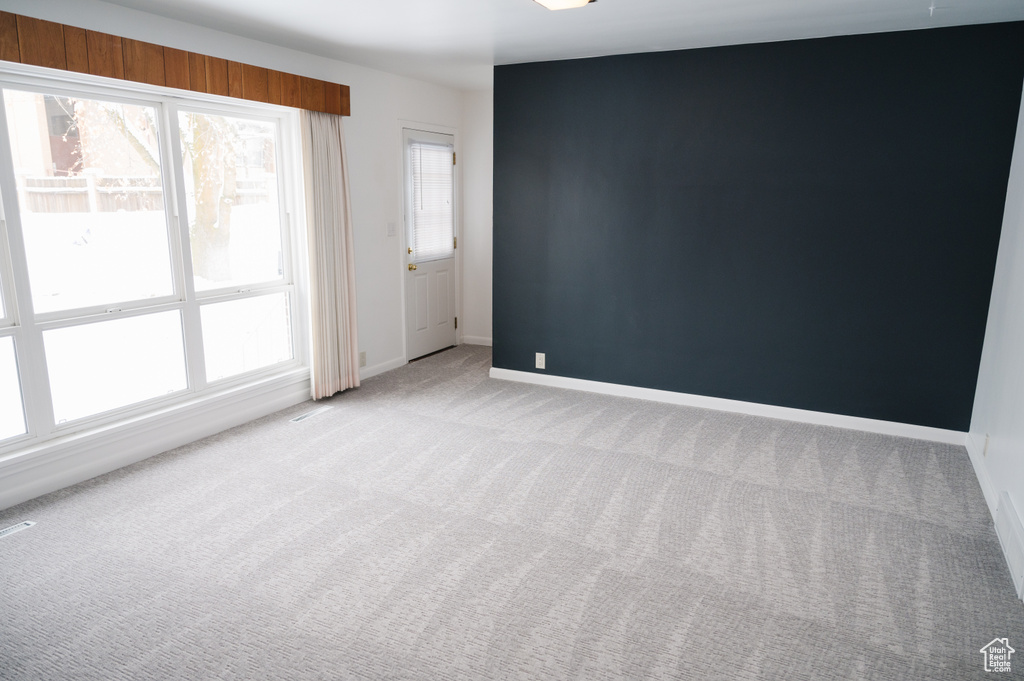 Spare room featuring carpet flooring and baseboards