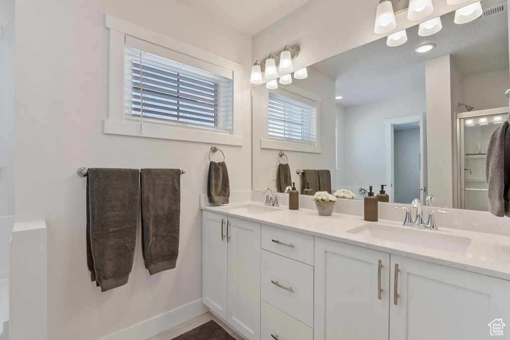 Bathroom with double vanity and a shower with shower door
