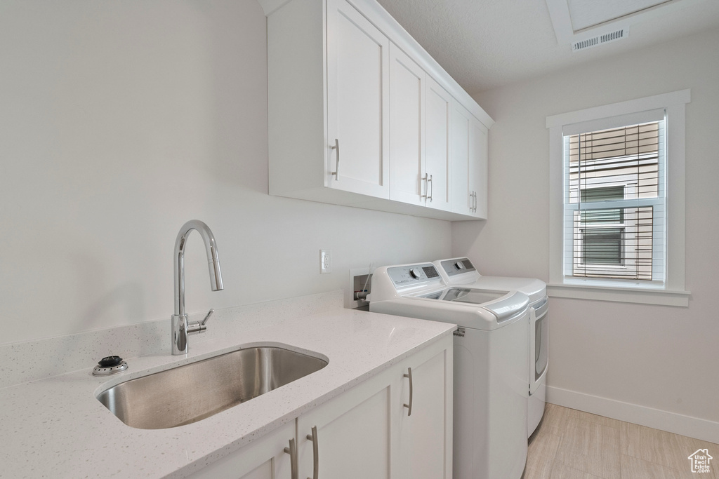 Washroom featuring separate washer and dryer and cabinet space