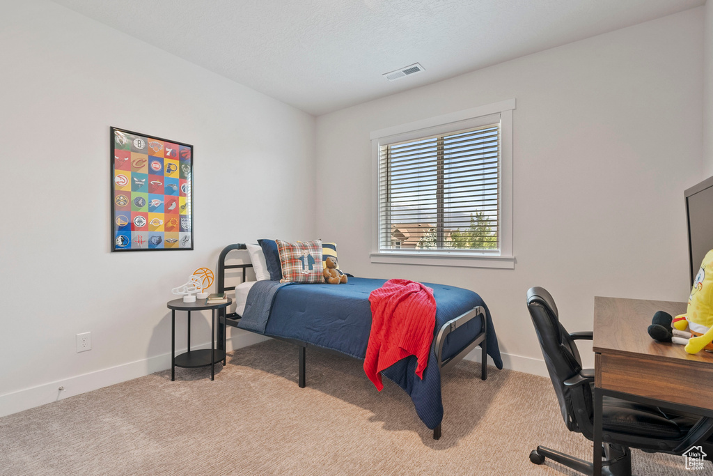 Bedroom with carpet floors and an office area