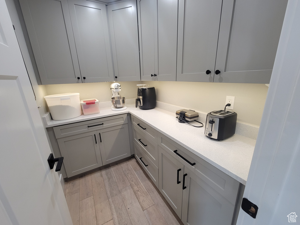 Kitchen featuring light wood finished floors, light countertops, and gray cabinets