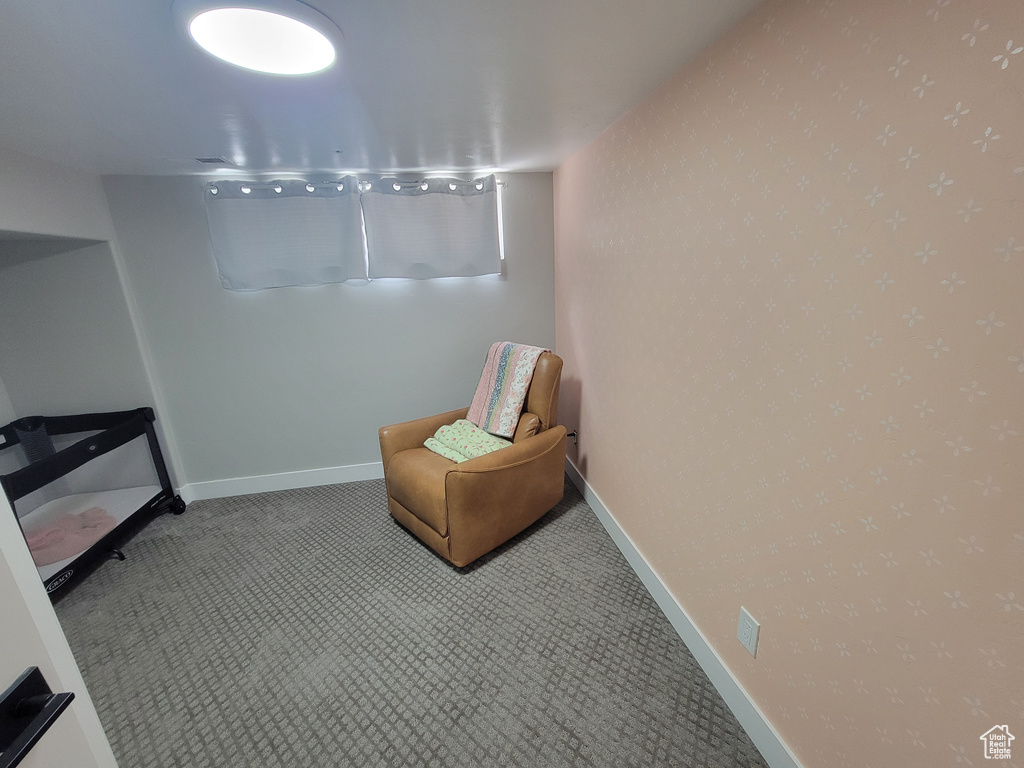 Living area featuring carpet flooring and baseboards