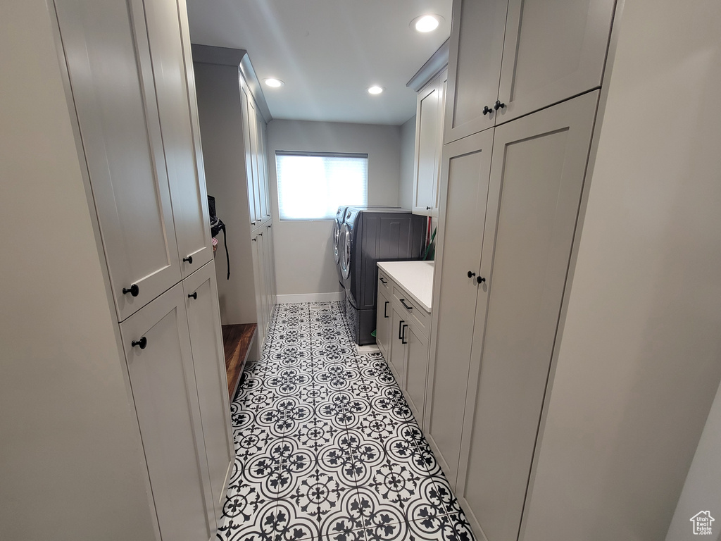 Washroom featuring washer and dryer, recessed lighting, cabinet space, and light tile patterned floors