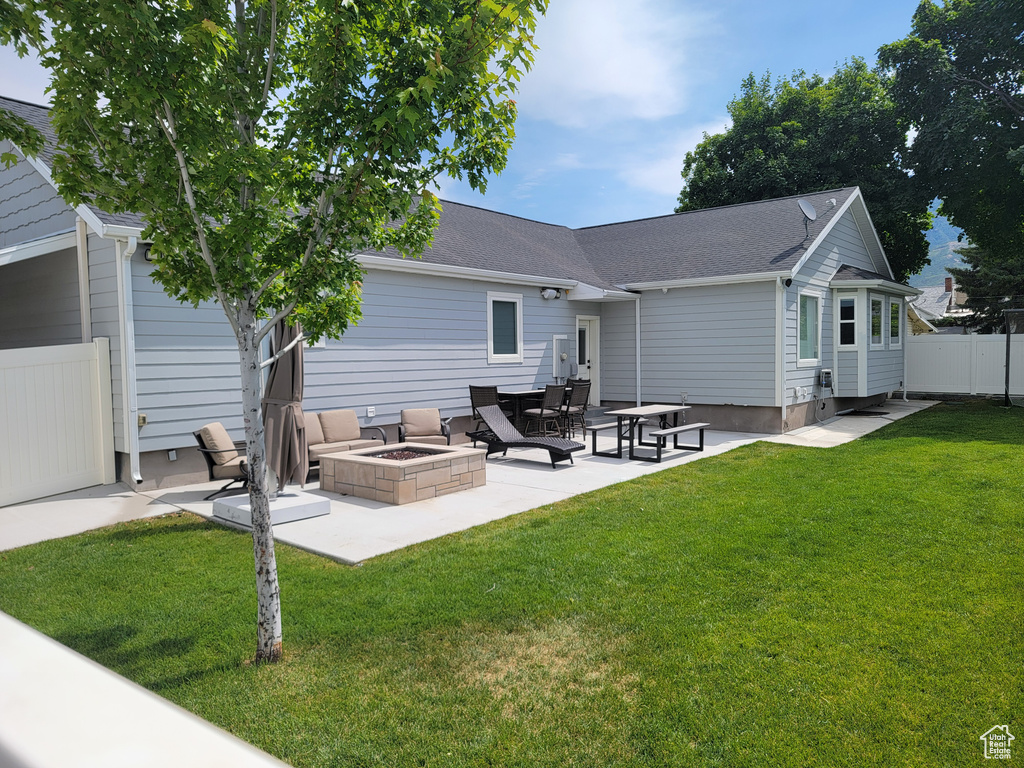 Back of house with a fire pit, a patio, and a shingled roof