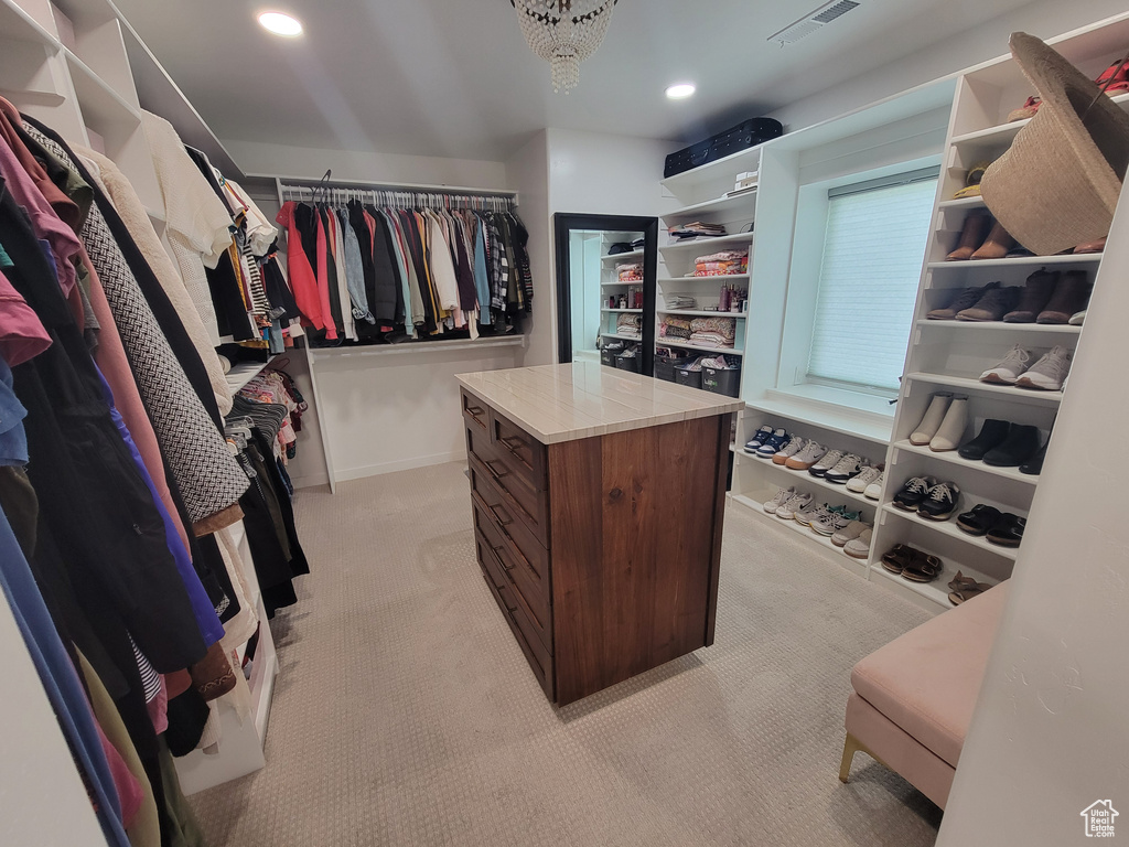 Walk in closet featuring light colored carpet