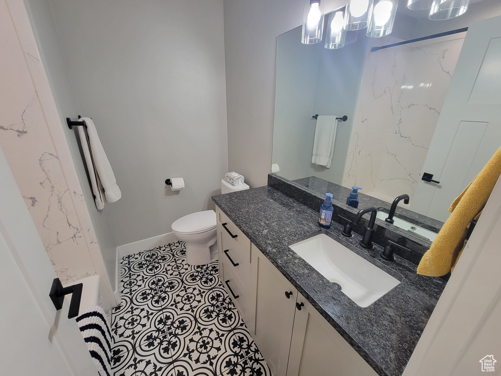 Bathroom with vanity, a marble finish shower, and tile patterned floors