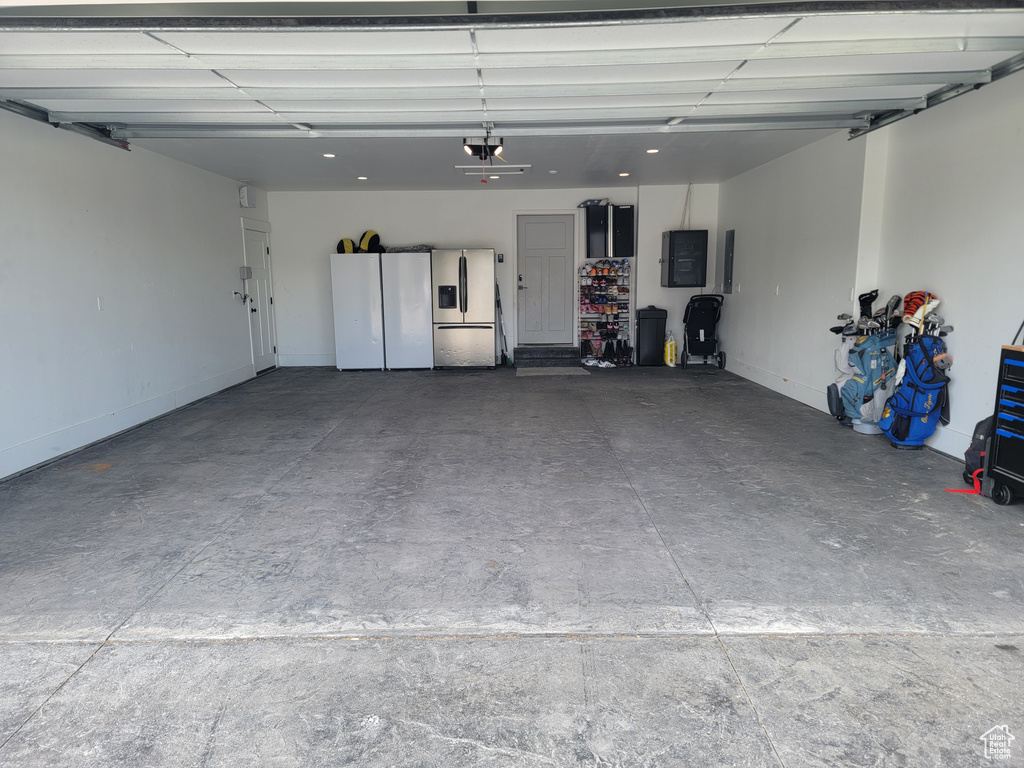 Garage with stainless steel fridge with ice dispenser and electric panel