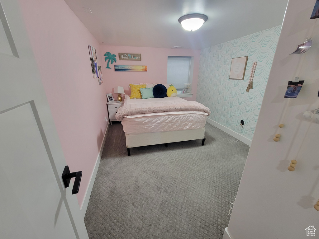 Bedroom with wallpapered walls and carpet flooring