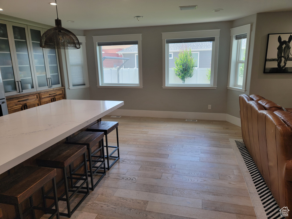 Dining area with light wood-style flooring and recessed lighting