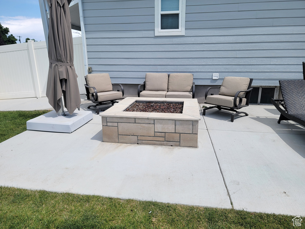 View of patio with an outdoor living space with a fire pit