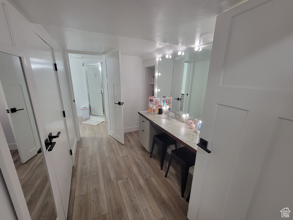 Full bathroom featuring wood finished floors, a shower stall, and vanity