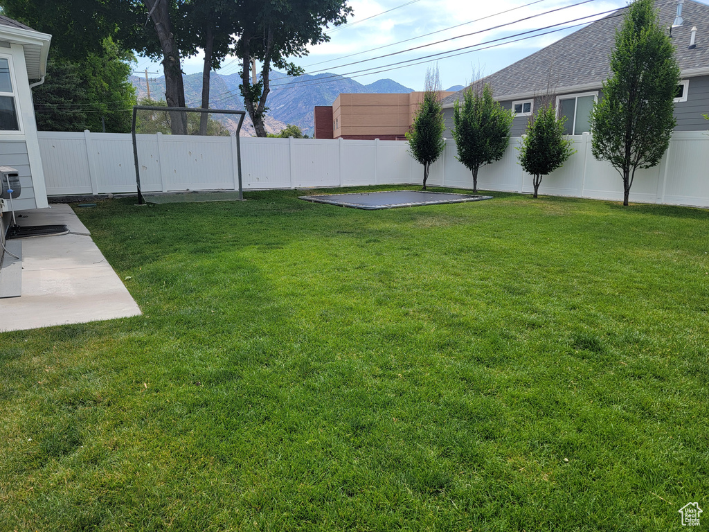 Fenced backyard with a mountain view and a patio
