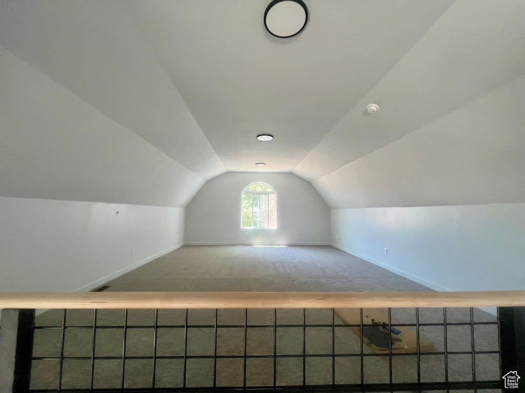 Additional living space featuring vaulted ceiling and carpet floors