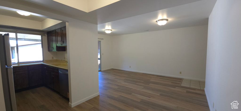 Kitchen featuring wood finished floors, dishwasher, and light countertops